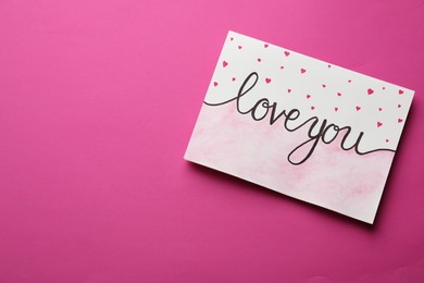 Card with phrase Love You and drawn little hearts on pink background. Space for text