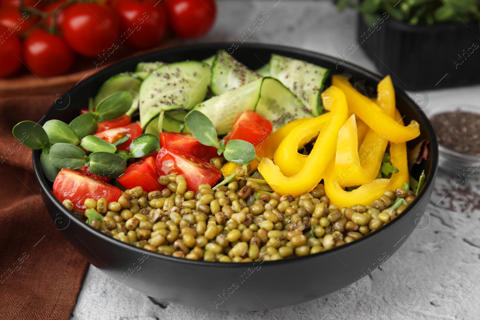 Photo of Bowl of salad with mung beans on white textured table, closeup