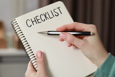 Photo of Woman filling Checklist with pen indoors, closeup