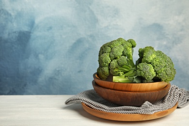 Photo of Plates with fresh broccoli on table. Types of cabbage