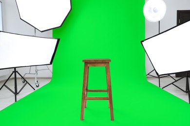 Image of Chroma key compositing. Green backdrop, stool and equipment in studio