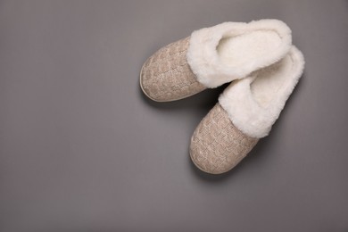 Pair of beautiful soft slippers on grey background, top view. Space for text