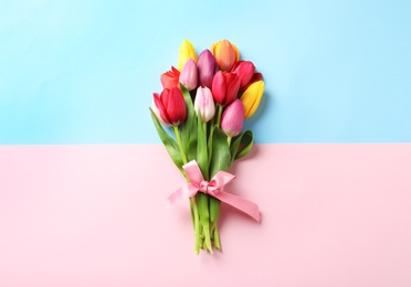 Beautiful bouquet of spring tulip flowers on color background, top view