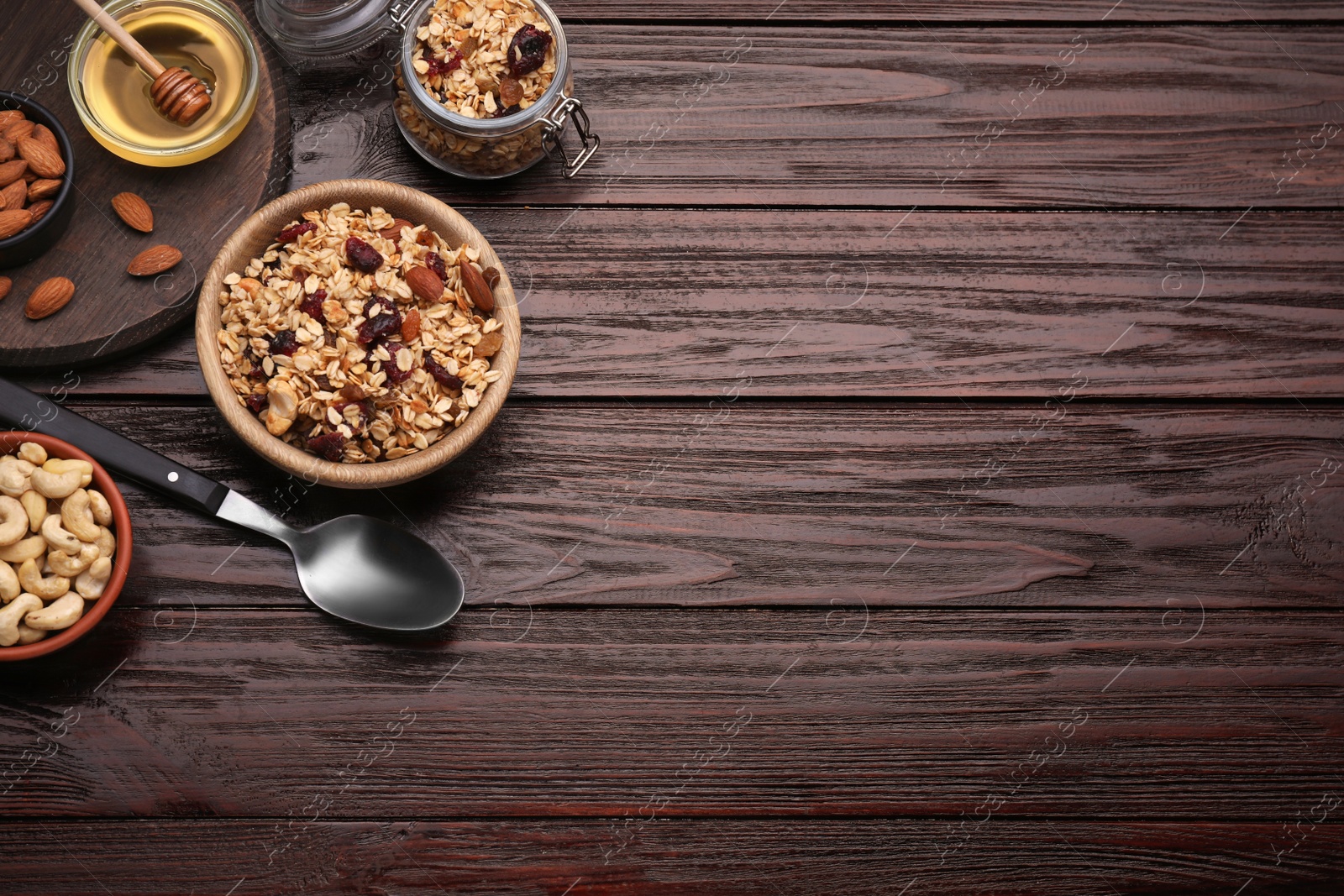 Photo of Tasty granola with nuts and dry fruits on wooden table, flat lay. Space for text