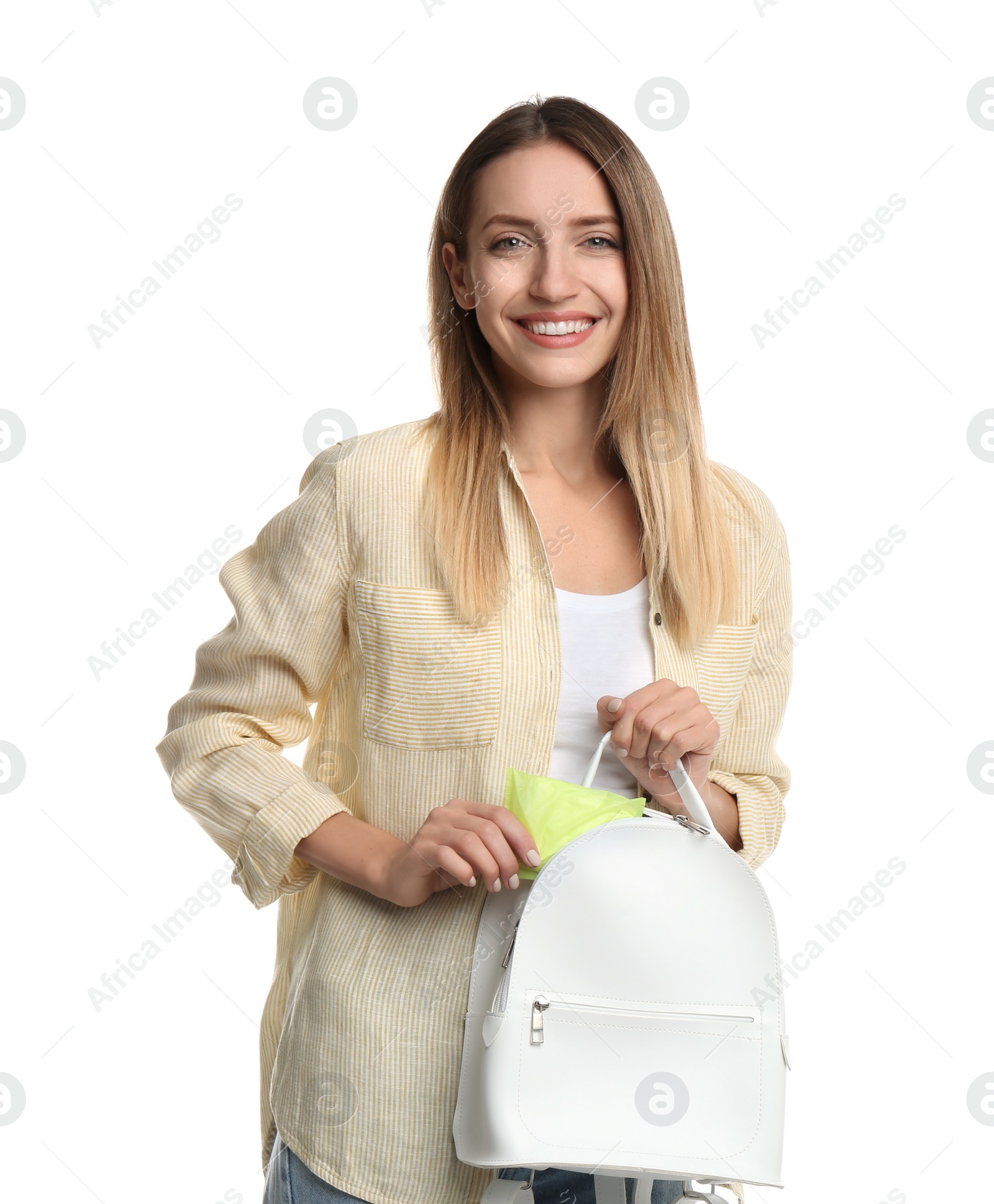 Photo of Happy young woman putting disposable menstrual pad into backpack on white background