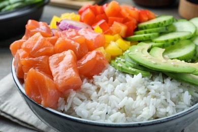 Photo of Delicious poke bowl with salmon and vegetables on table, closeup