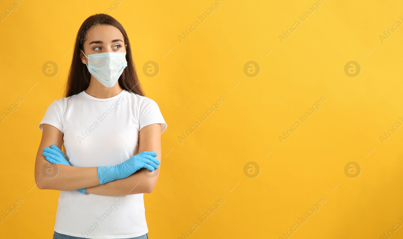 Photo of Woman wearing protective face mask and medical gloves on yellow background. Space for text