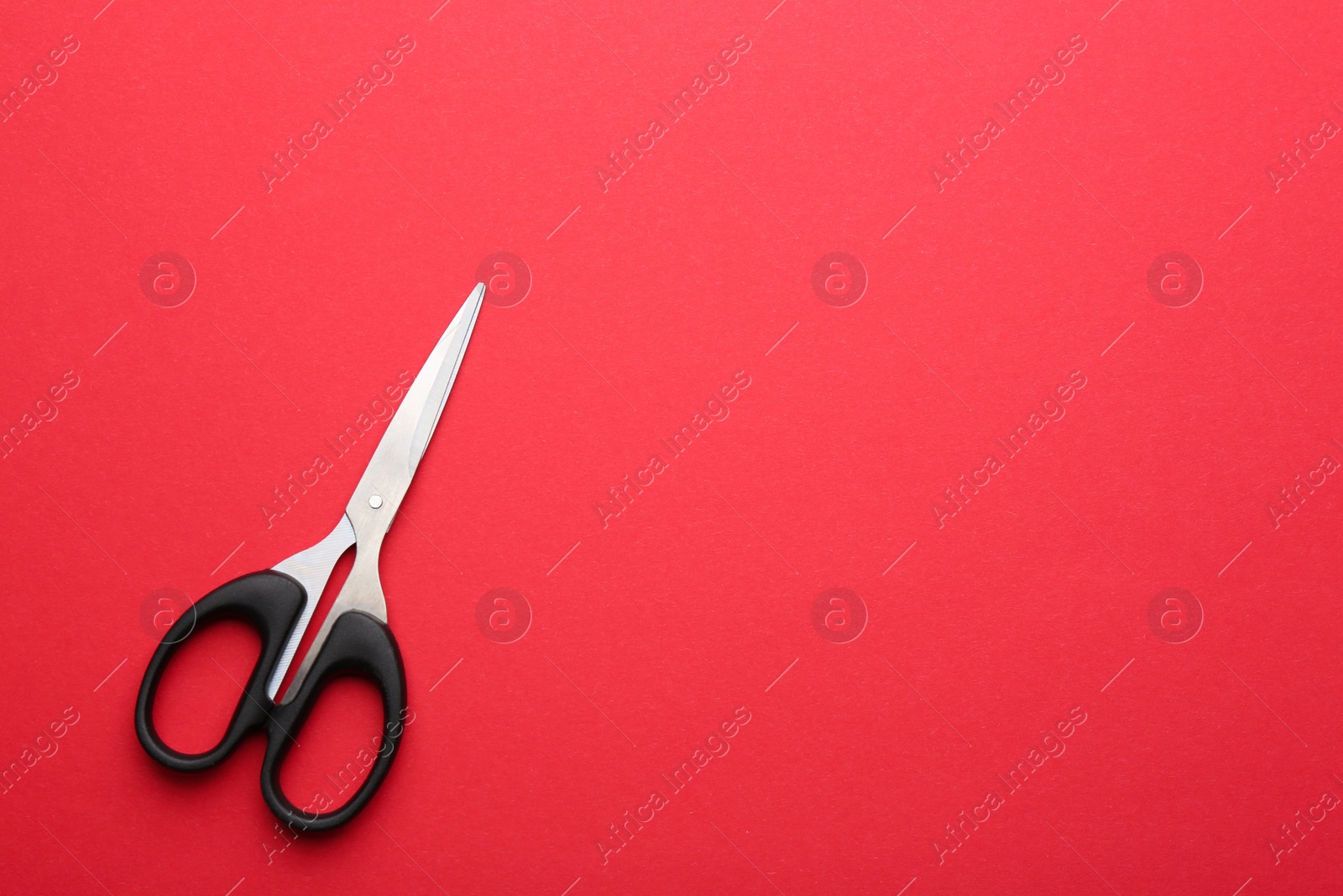 Photo of Pair of sharp scissors on color background, top view. Space for text