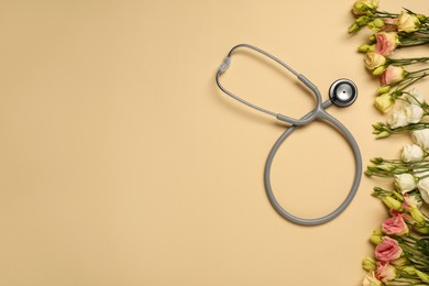 Photo of Stethoscope and flowers on dark beige background, flat lay with space for text. Happy Doctor's Day