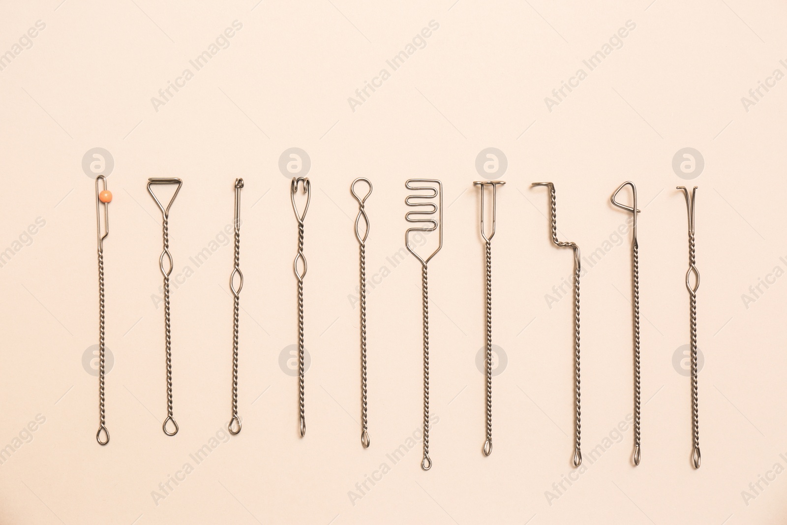 Photo of Set of logopedic probes for speech therapy on beige background, flat lay