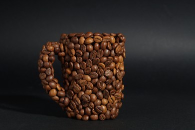 Photo of Cup made of coffee beans against black background