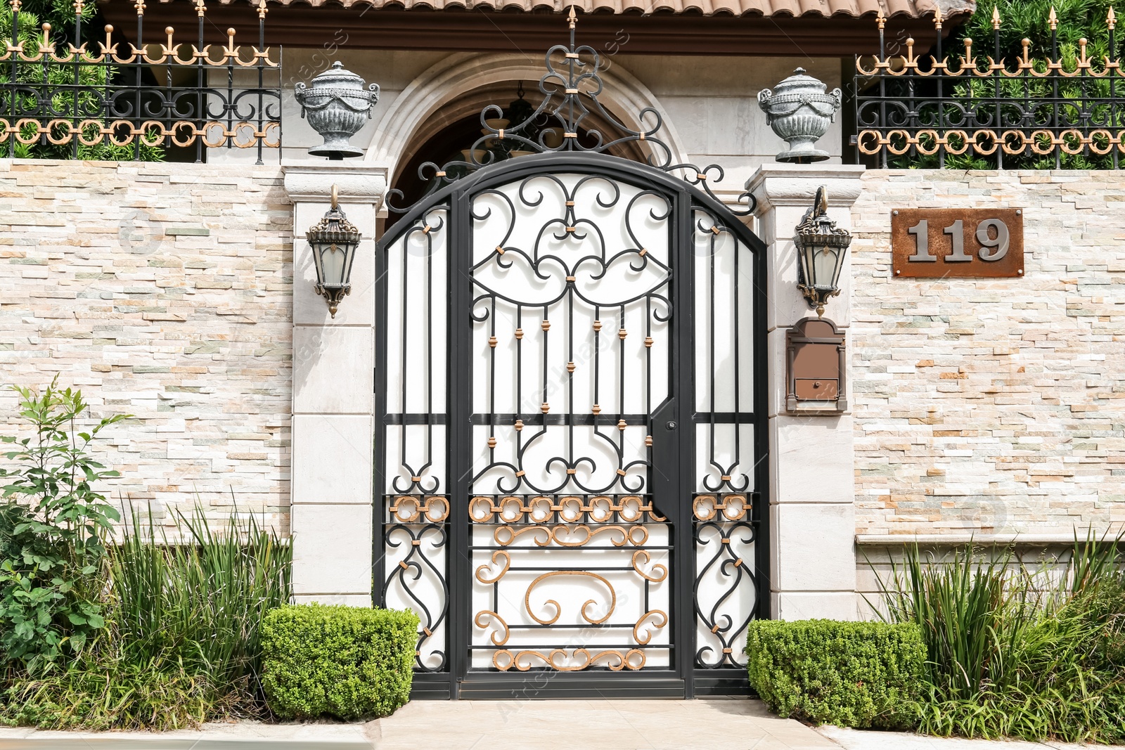 Photo of Black metal gates near beautiful house outdoors