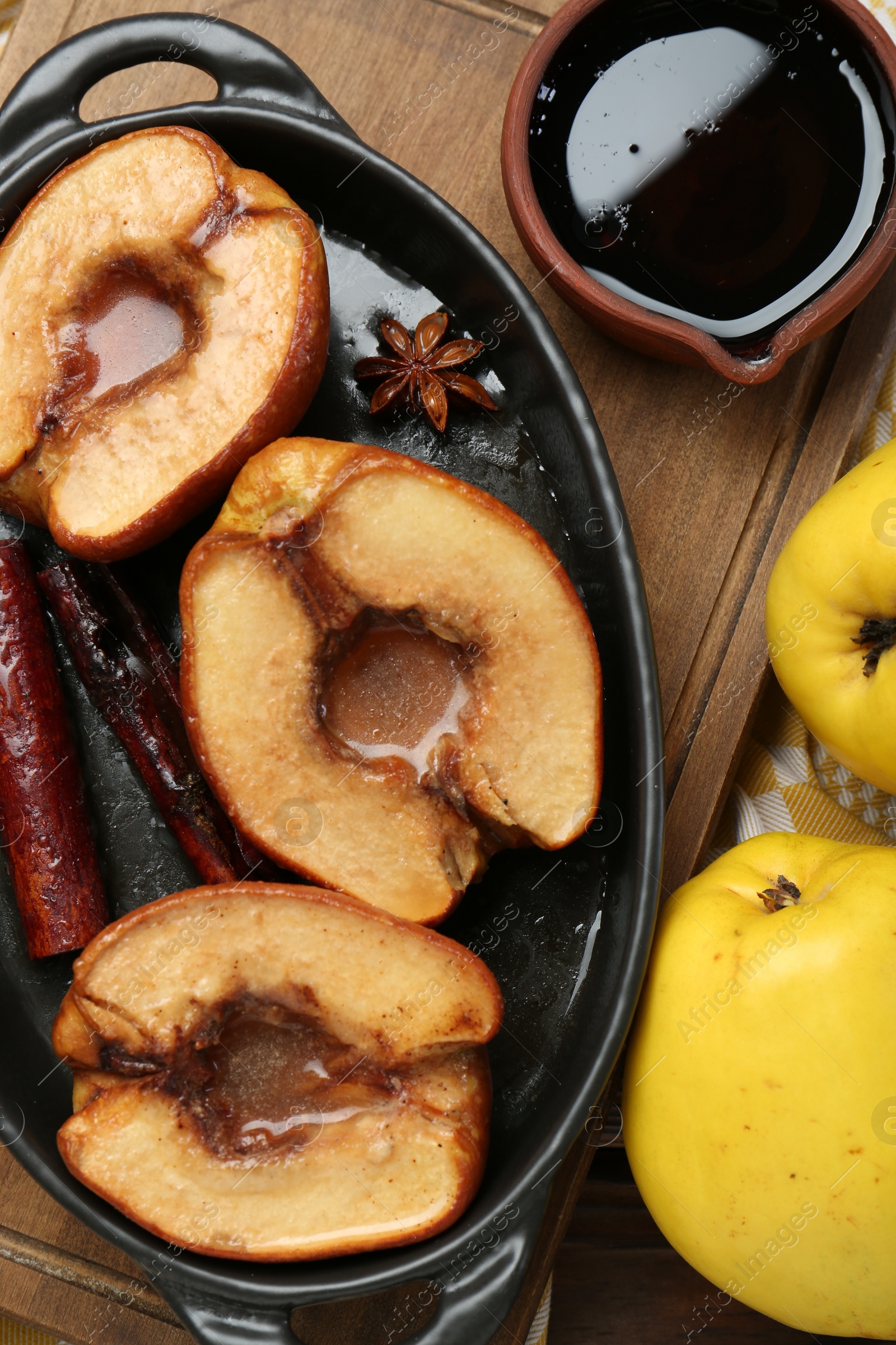 Photo of Tasty baked quinces served with sauce on table, flat lay