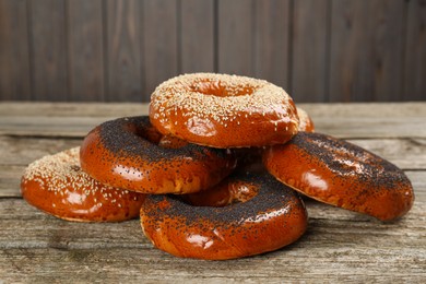 Photo of Many delicious fresh bagels on wooden table