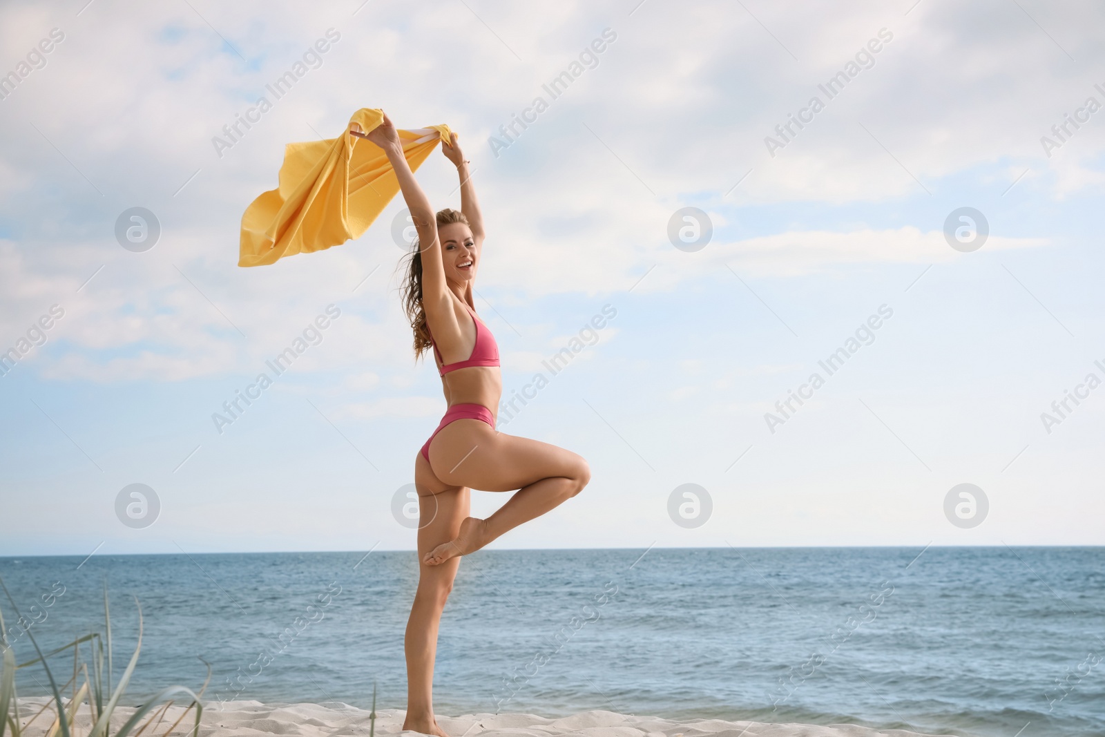 Photo of Beautiful woman with bright beach towel near sea