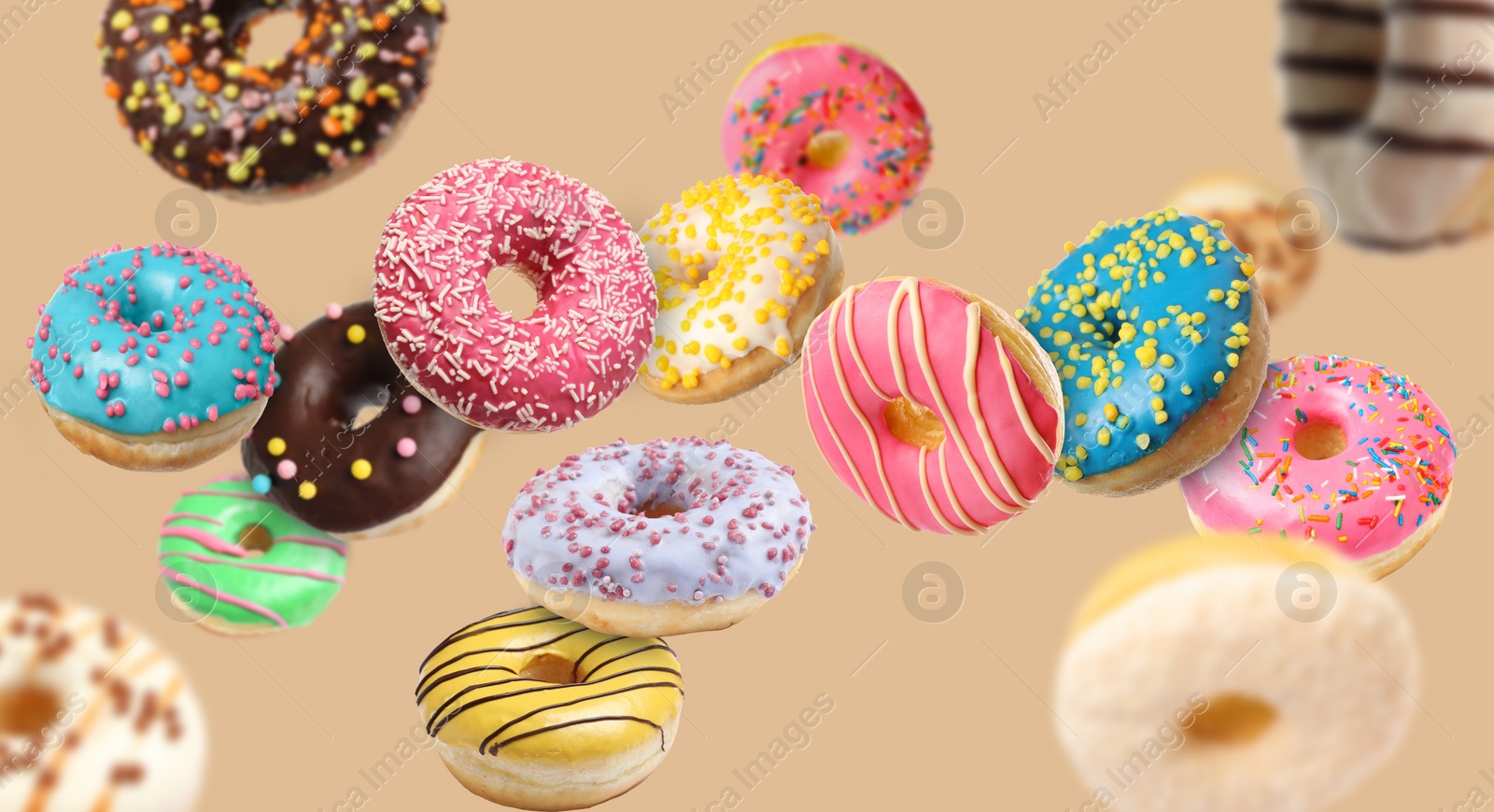 Image of Many sweet tasty donuts flying on beige background