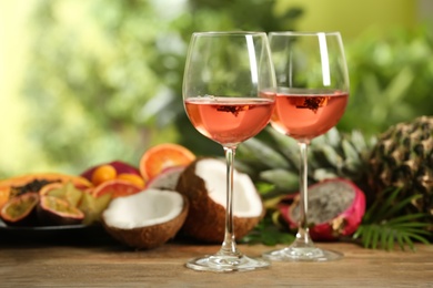 Delicious exotic fruits and wine on wooden table