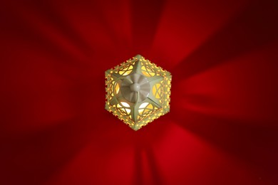 Photo of Decorative Arabic lantern on red background, top view