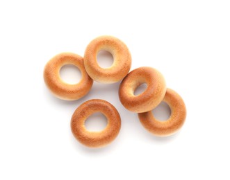 Photo of Many tasty dry bagels (sushki) isolated on white, top view