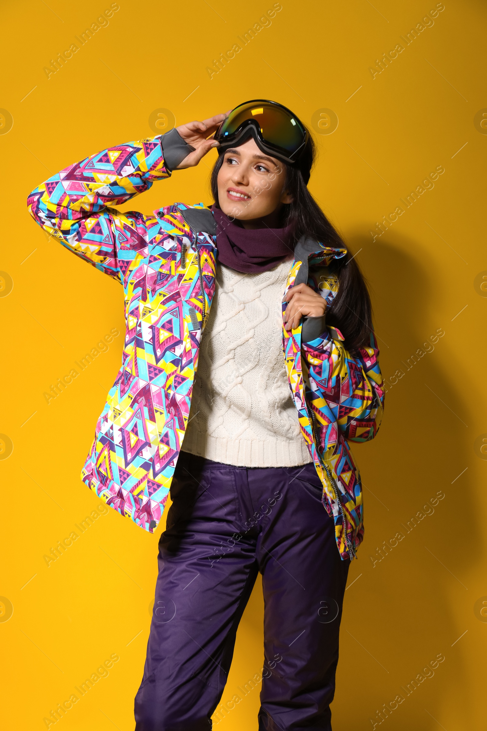 Photo of Woman wearing stylish winter sport clothes on yellow background