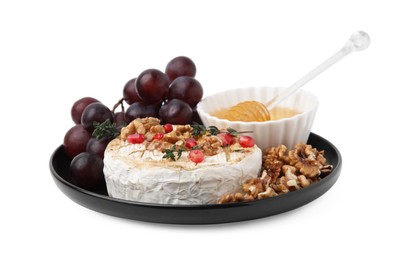 Plate with tasty baked camembert, honey, grapes, walnuts and pomegranate seeds isolated on white