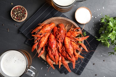 Photo of Flat lay composition with delicious red boiled crayfishes on black table