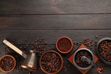 Vintage manual coffee grinder with beans, powder and jezve on wooden table, flat lay. Space for text