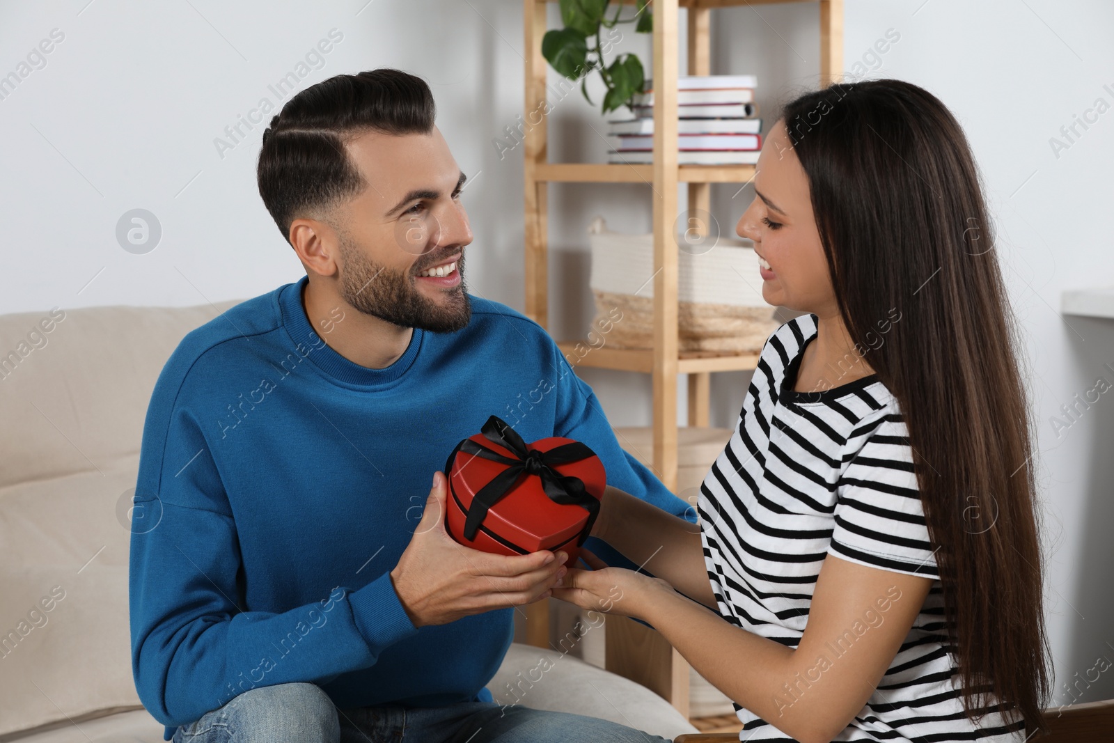 Photo of Lovely couple with beautiful gift at home