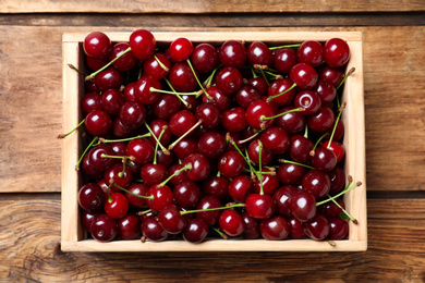 Photo of Sweet juicy cherries on wooden table, top view