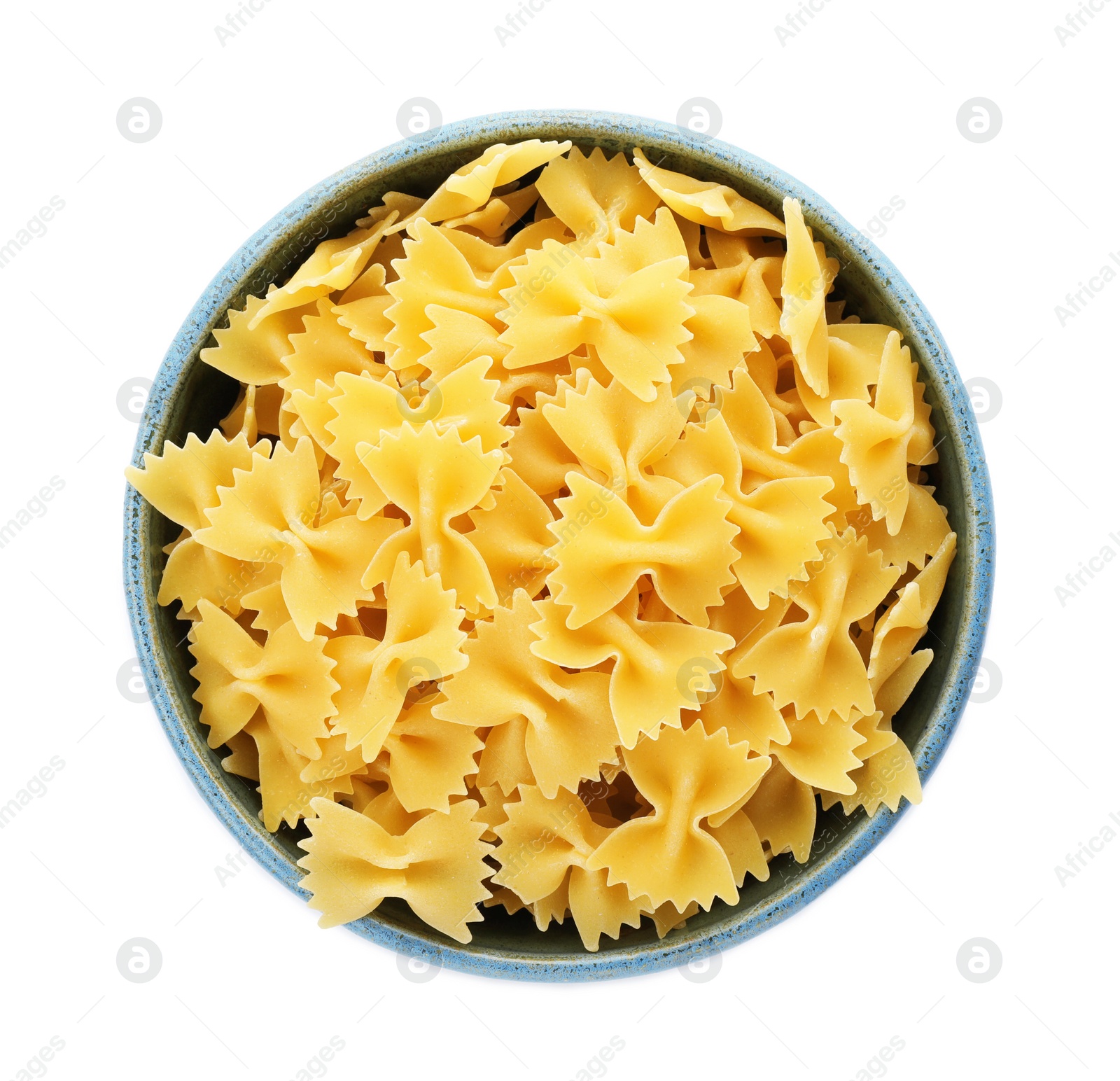 Photo of Bowl with uncooked farfalle pasta on white background, top view