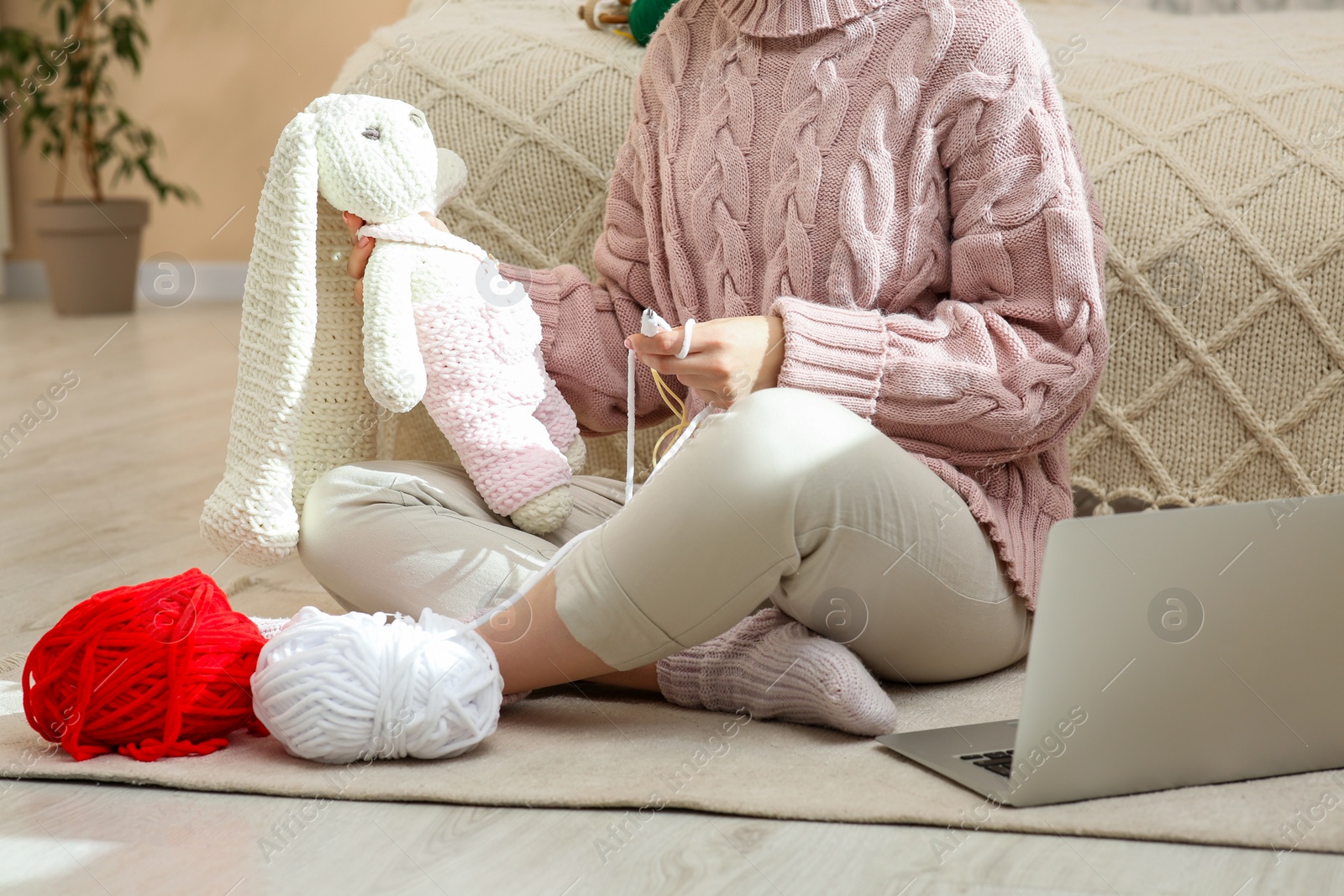 Photo of Woman learning to knit with online course at home, closeup. Handicraft hobby