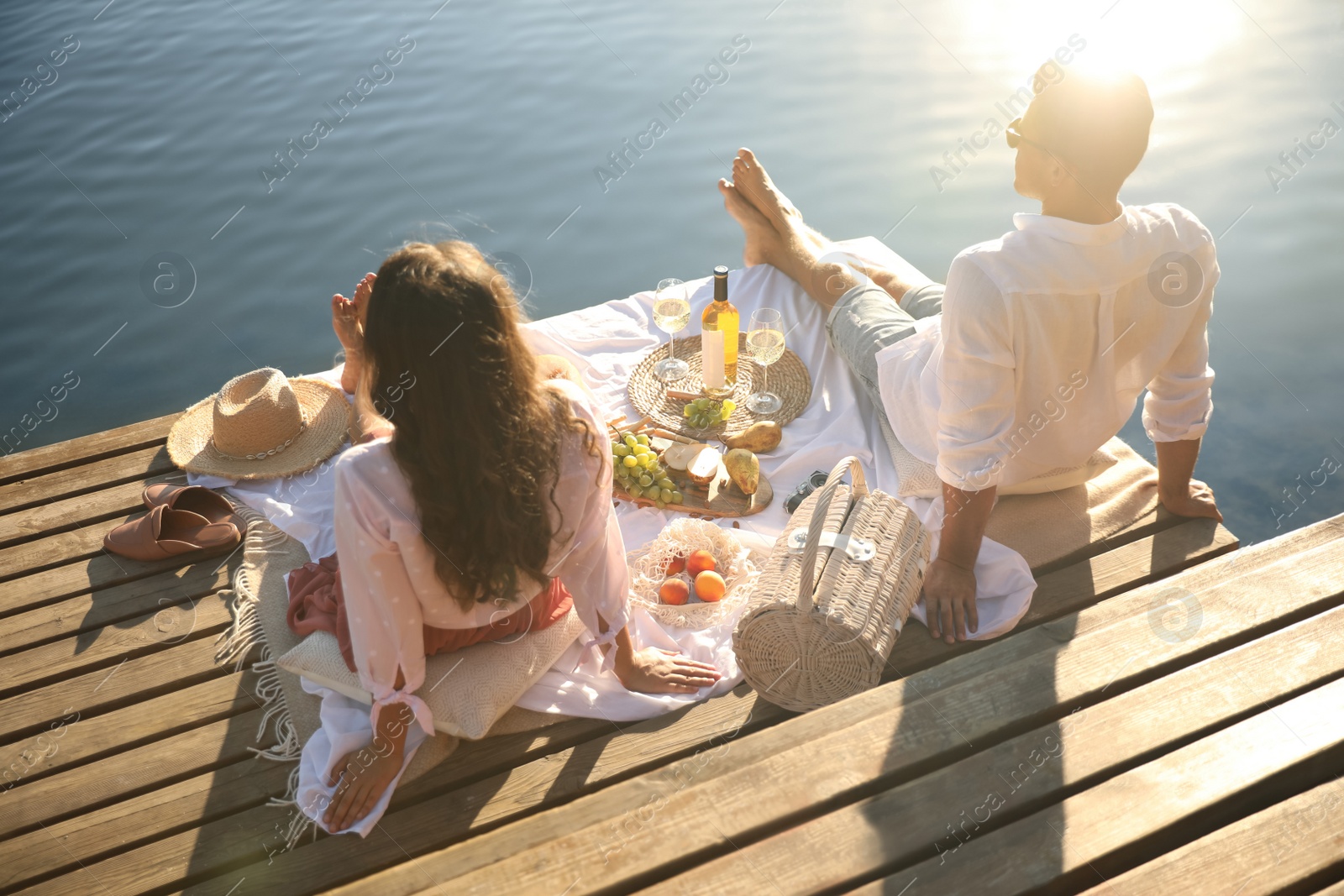 Photo of Happy couple spending time on pier at picnic