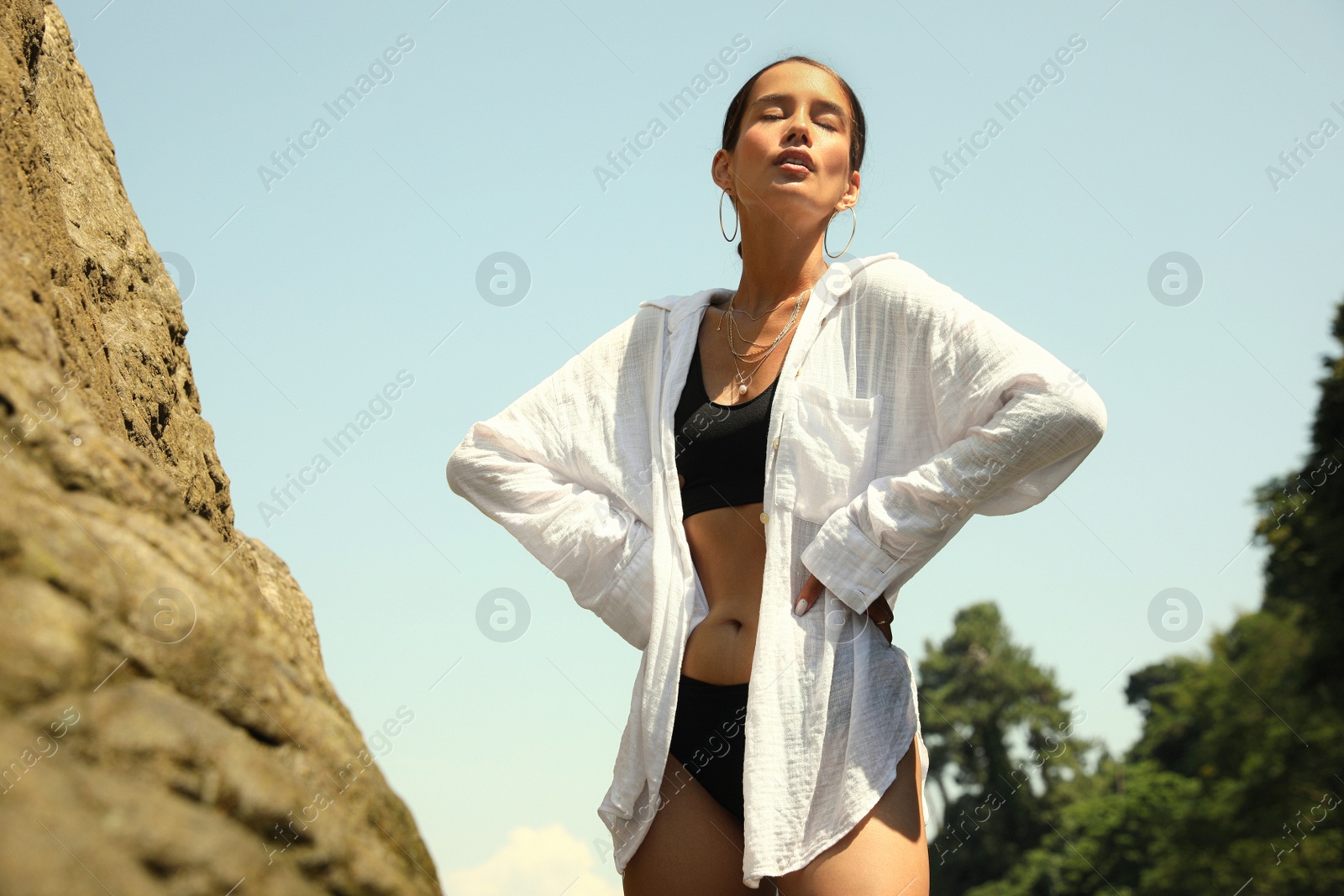 Photo of Beautiful young woman in stylish bikini outdoors, low angle view