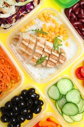 Set of plastic containers with fresh food on yellow background, flat lay