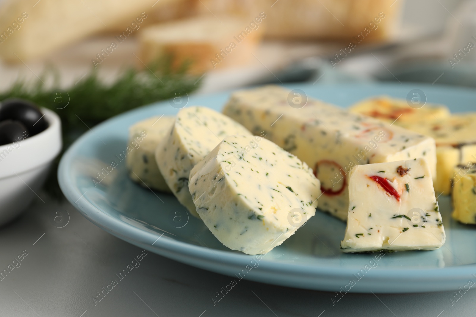 Photo of Tasty butter with herbs and spices on white table, closeup