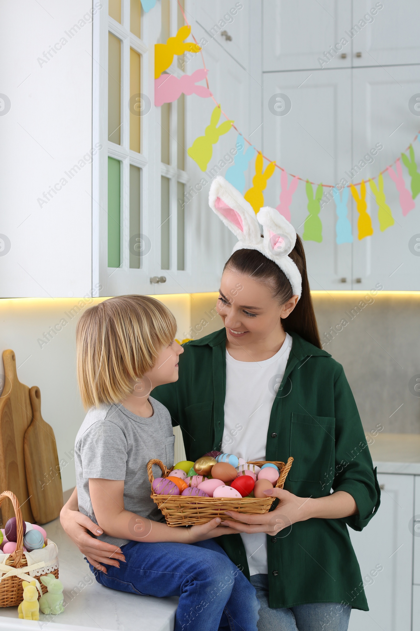 Photo of Mother and her son with Easter eggs in kitchen