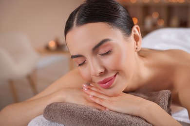 Photo of Young woman resting on massage couch in spa salon, closeup