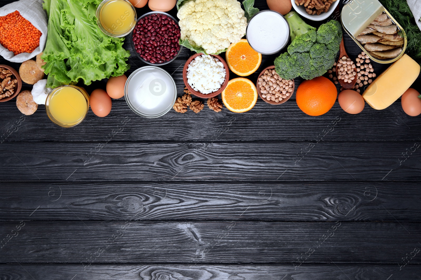 Photo of Set of natural food high in calcium on black wooden table, flat lay. Space for text