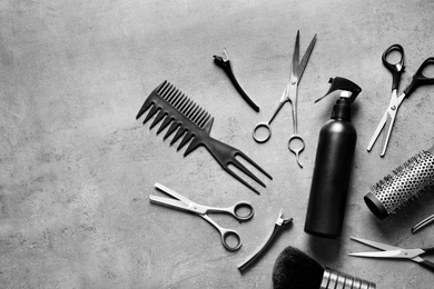 Photo of Flat lay composition with scissors and other hairdresser's accessories on grey background. Space for text