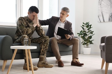 Professional psychotherapist working with military man in office