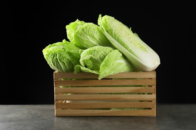 Photo of Fresh ripe Chinese cabbages in wooden crate on grey table