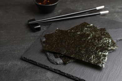 Dry nori sheets and chopsticks on black table