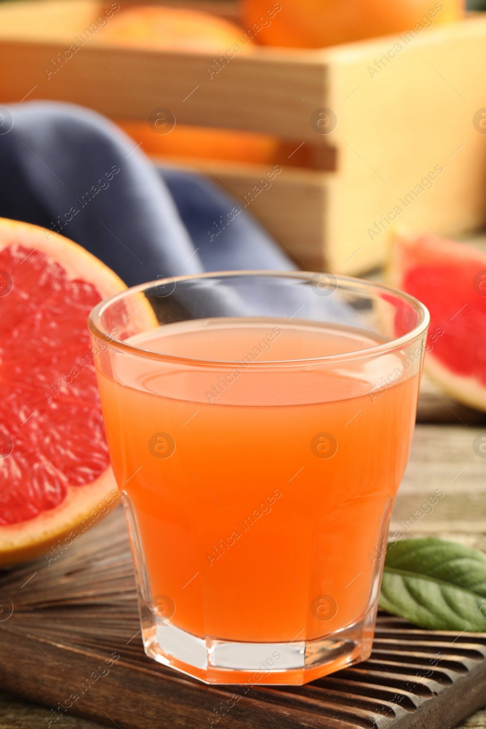 Photo of Glass of delicious grapefruit juice on wooden table