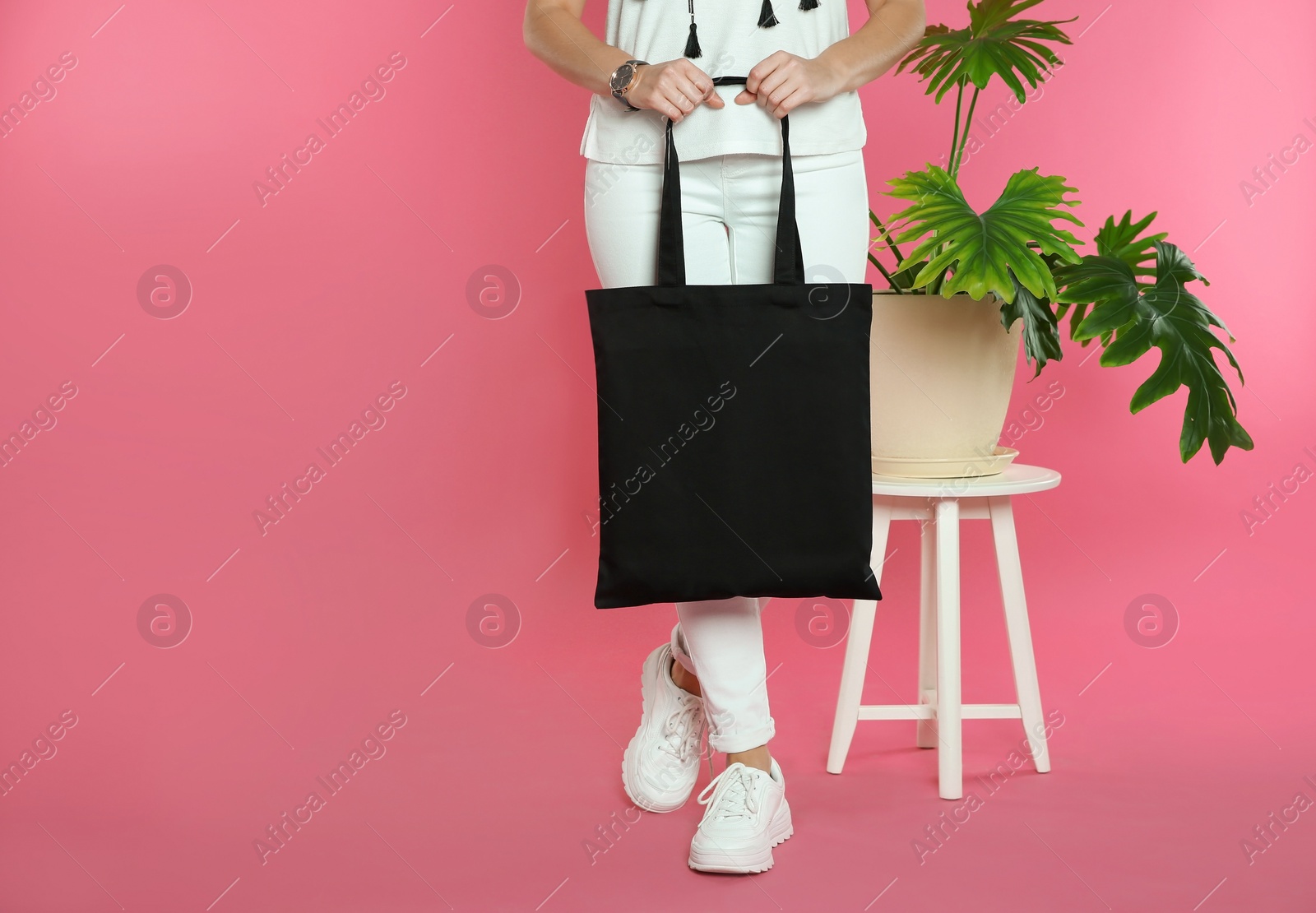 Photo of Woman with eco bag near green plant on color background. Mock up for design