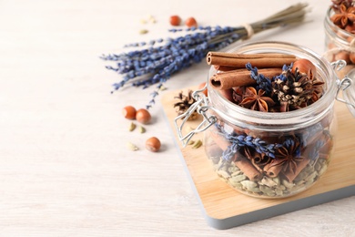 Aroma potpourri with different spices on white wooden table, space for text