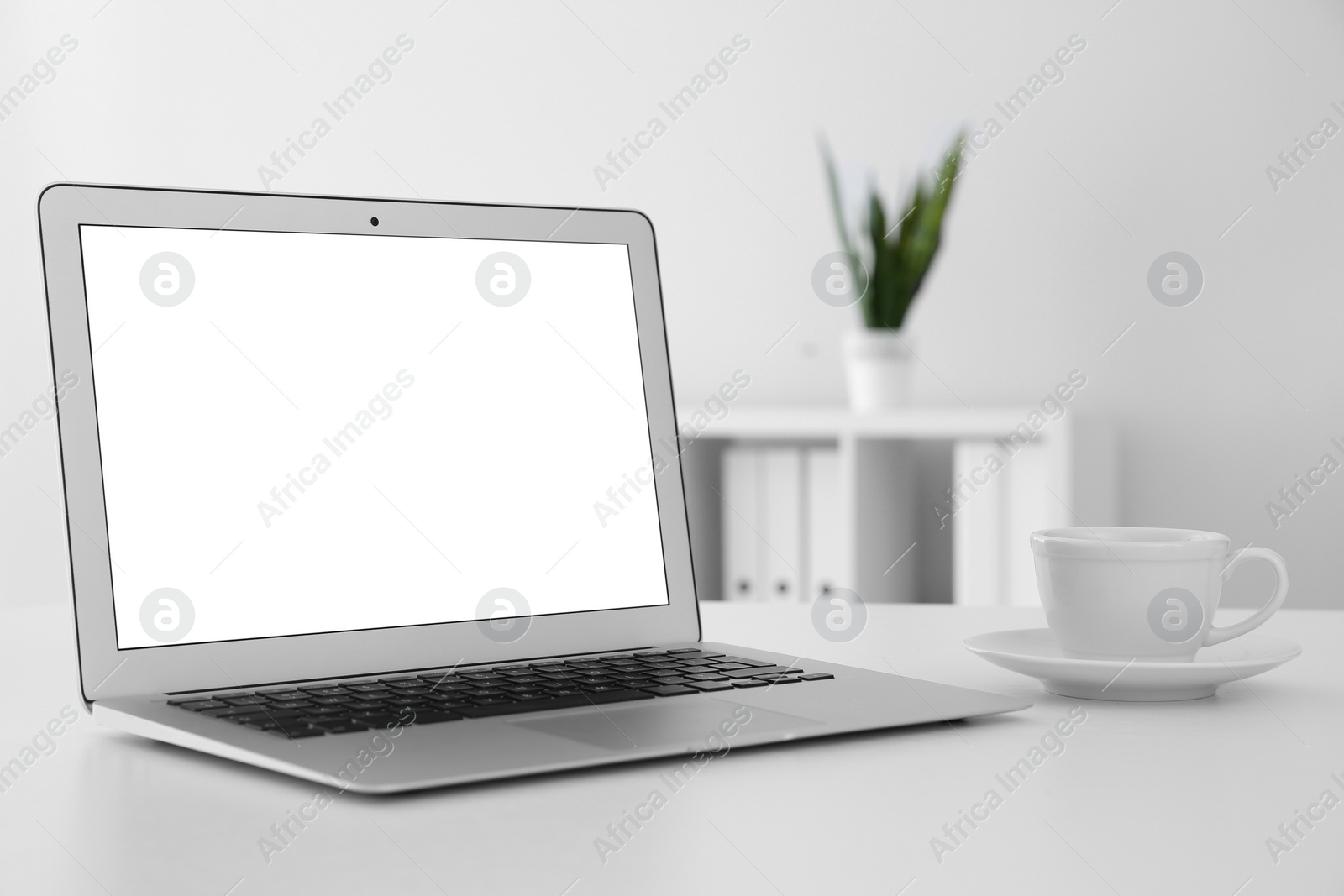 Photo of Comfortable workplace with modern laptop on table in office. Mockup for design