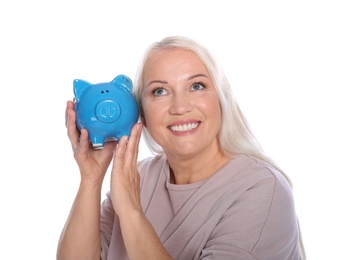 Mature woman with piggy bank on white background