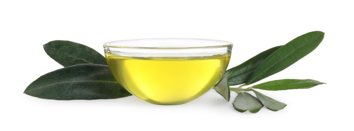 Olive oil in glass bowl and leaves on white background. Healthy cooking