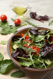 Photo of Tasty fresh vegetarian salad and ingredients on grey table, closeup