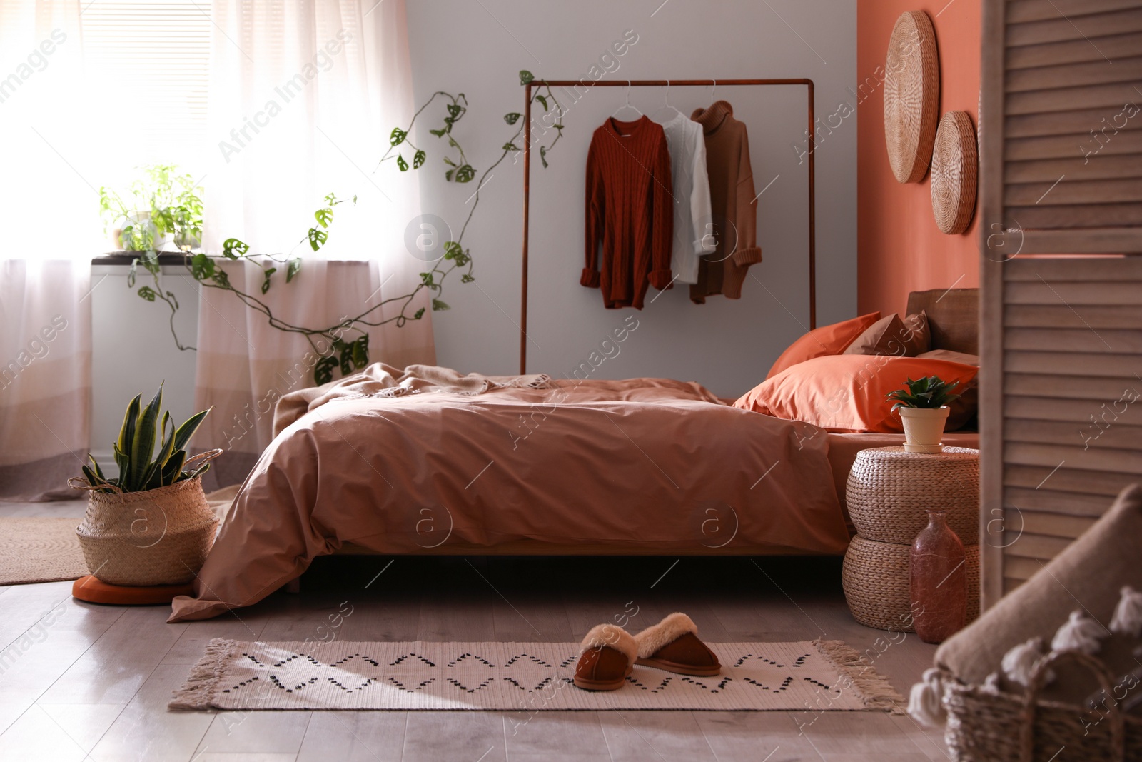 Photo of Bed with orange and brown linens in stylish room interior